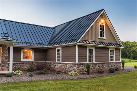 gray house and green metal roof|dark grey brick house.